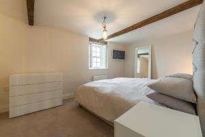 a bedroom with a large white bed and a window at Barn Cottage 6 in Salthouse