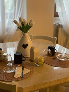 un tavolo con due piatti e un vaso con fiori di Casa Vacanze “Il Sogno” a Bagnoregio