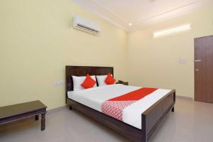 a bedroom with a bed with red pillows at Collection O Hotel Albert in Jaipur