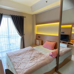 a bedroom with a bed and a large window at Springwood Residence by Tentrem Room in Warungmangga