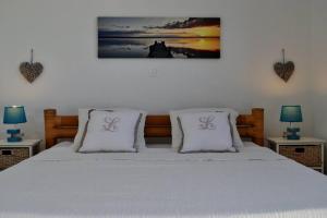 um quarto com uma cama com duas almofadas em La Villa Cocoon prestige et vue mer em Sainte-Luce