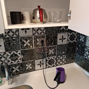 fregadero con manguera de agua junto a una pared de azulejos en Home in love, en Esenyurt