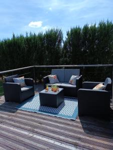 un patio con 2 sofás y una mesa en una terraza en Chalet Miquéou Gers en Marseillan