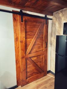 a wooden door in a room with a refrigerator at Marco’s Studio in Făgăraş