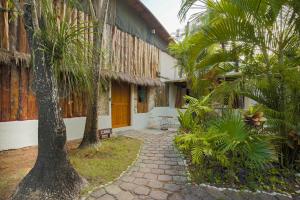 un cortile di una casa con palme e un vialetto di OMA CANCUN - Holistic Healing Center a Cancún