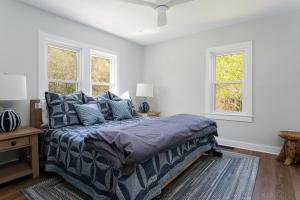 a bedroom with a bed and two windows at Idyllic Asheville Countryside Home on 70 Acres in Mars Hill