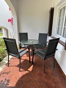 Casa Peña en Son Bou في سون بو: طاولة زجاجية وكراسي على الفناء