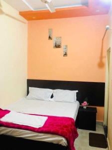 una camera da letto con un letto con una coperta rossa sopra di OYO The Bliss Guest House & Restaurant a Gwalior