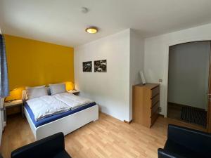 um quarto com uma cama e uma parede amarela em alscher's holiday home em Interlaken