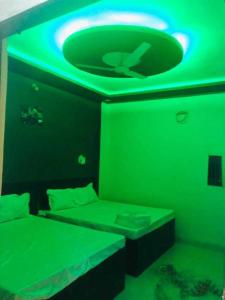 um quarto verde com uma cama e um tecto verde em OYO The Bliss Guest House & Restaurant em Gwalior