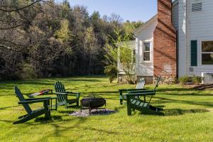 a group of picnic tables and chairs around a fire pit at Idyllic Asheville Countryside Home on 70 Acres in Mars Hill