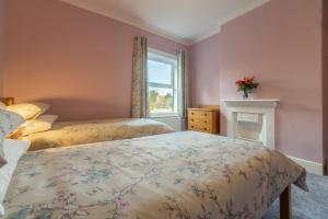 a bedroom with two beds and a window at Heacham Hidey Hole in Heacham