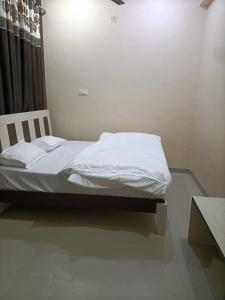 a white bed in a room with a table at OYO IAE566 Neelkanth Hotel in Rewāri