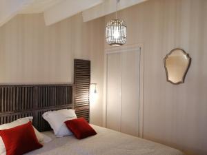 a bedroom with a bed with red pillows and a mirror at Chambre d'hôte ensoleillée à 300m de la plage in La Guérinière