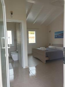 - une grande chambre avec un lit et des toilettes dans l'établissement Is Arenas Biancas Agriturismo, à Teulada