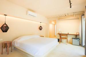 1 dormitorio con cama blanca y escritorio en OMA CANCUN - Holistic Healing Center, en Cancún