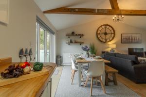 a kitchen and living room with a table and a couch at Willow Lodge in Holme next the Sea