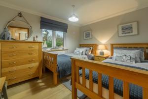 a bedroom with two beds and a dresser and a mirror at Willow Lodge in Holme next the Sea