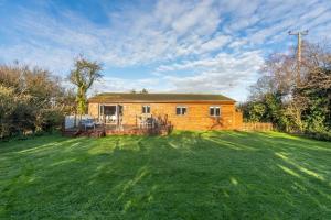 a brick house in a yard with a large lawn at Willow Lodge in Holme next the Sea