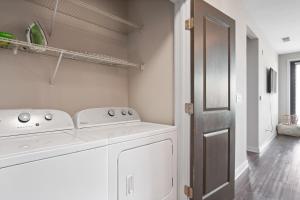 a white laundry room with a washer and dryer at This Is Luxury in Atlanta