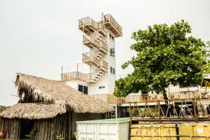 un edificio alto con un árbol delante de él en Marine Surf en El Paredón Buena Vista