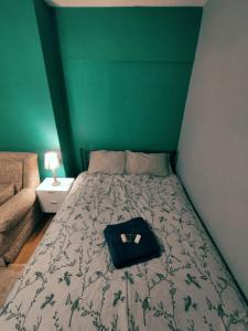 a bed in a room with a green wall at We love Henbury in Bristol