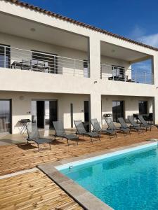 a villa with a swimming pool in front of a house at Villa Cargese in Cargèse