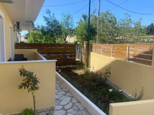 un jardín en el lateral de una casa con una valla en Adriana's Summer House en Kassiopi