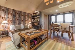 een slaapkamer met een bed en een tafel en een eetkamer bij The Bothy in Ringstead