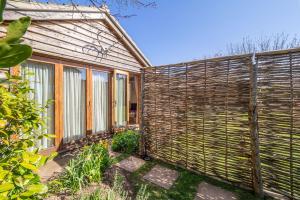 a wooden privacy fence next to a house at The Bothy in Ringstead +6 photos
