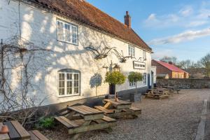 a group of picnic tables in front of a building at The Bothy in Ringstead
