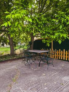 een picknicktafel en banken onder een boom bij Studio GIANNIS in Souflíon