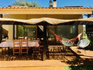 Cette maison dispose d'une terrasse avec une table et des chaises. dans l'établissement Villa Bamboo by Costabravaway, à Calonge