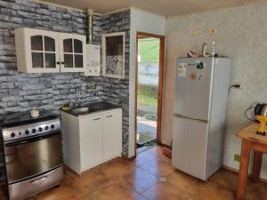 uma cozinha com um frigorífico branco e um lavatório em Casa completa em Castro
