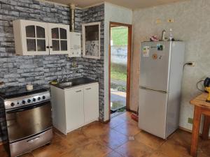 uma cozinha com um frigorífico branco e um fogão em Casa completa em Castro