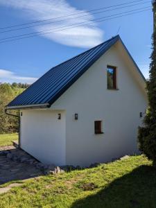 a white building with a solar roof at Chaty Vážka in Štiavnické Bane