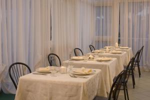 un grupo de mesas con manteles blancos. en Hotel Consuelo, en Riccione