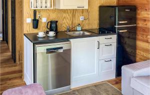 a small kitchen with a sink and a refrigerator at Amazing Home In Rydzewo With Sauna in Rydzewo