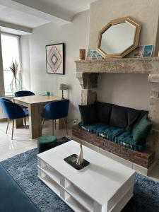 a living room with a couch and a table at La maison des lauriers in Valognes