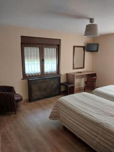 1 dormitorio con cama, escritorio y espejo en Hotel Rural Cabrales, en Carreña