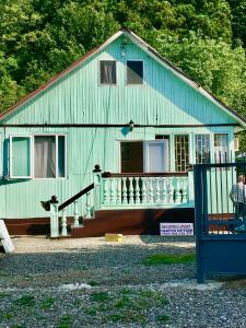 una casa azul con porche y una persona parada fuera en Green house in Gonio economy class, en Kvariati