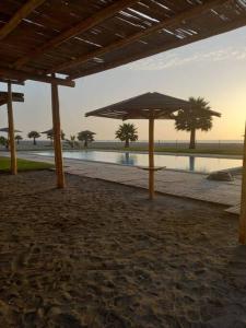 Chincha BajaThe Pacific Cottage的海滩上的一张桌子和一把遮阳伞