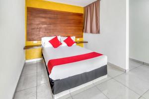 a bedroom with a bed with red pillows at OYO Hotel Familiar Tollan in Cholula