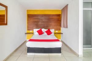 a hotel room with a bed with red pillows at OYO Hotel Familiar Tollan in Cholula