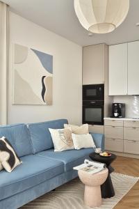 a living room with a blue couch and a table at ŻOLI STORK APARTMENTS - Hubnera 5 in Warsaw