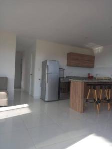 Chincha BajaThe Pacific Cottage的配有冰箱和桌子的厨房