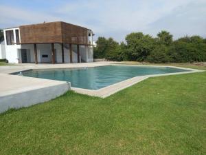 a swimming pool in the yard of a house at The Pacific Cottage in Chincha Baja