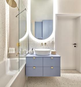 a bathroom with a sink and a mirror at ŻOLI STORK APARTMENTS - Hubnera 5 in Warsaw