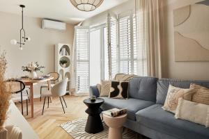 a living room with a blue couch and a table at ŻOLI STORK APARTMENTS - Hubnera 5 in Warsaw