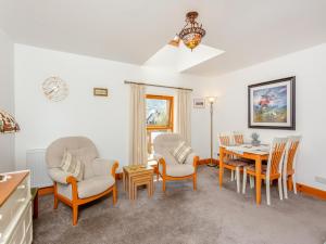 a living room with a dining room table and chairs at Fyvie Cottage in Banavie